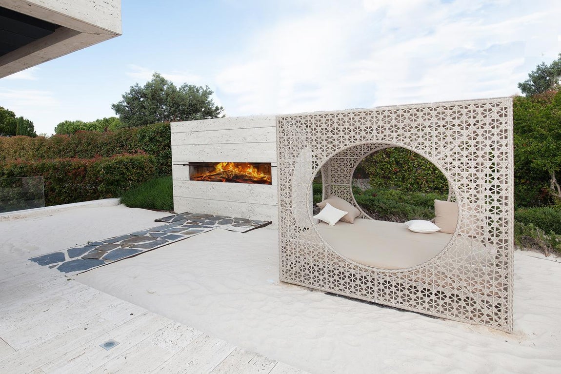 La exclusiva propiedad de La Moraleja para vivir rodeado de lujos. La casa está pensada para disfrutar tanto del interior como sus comodidades exteriores, donde merece una mención especial la zona de barbacoa, integrada sobre una pequeña playa artificial y construida bajo un diseño moderno y minimalista que hacen de ella una pieza clave del jardín.