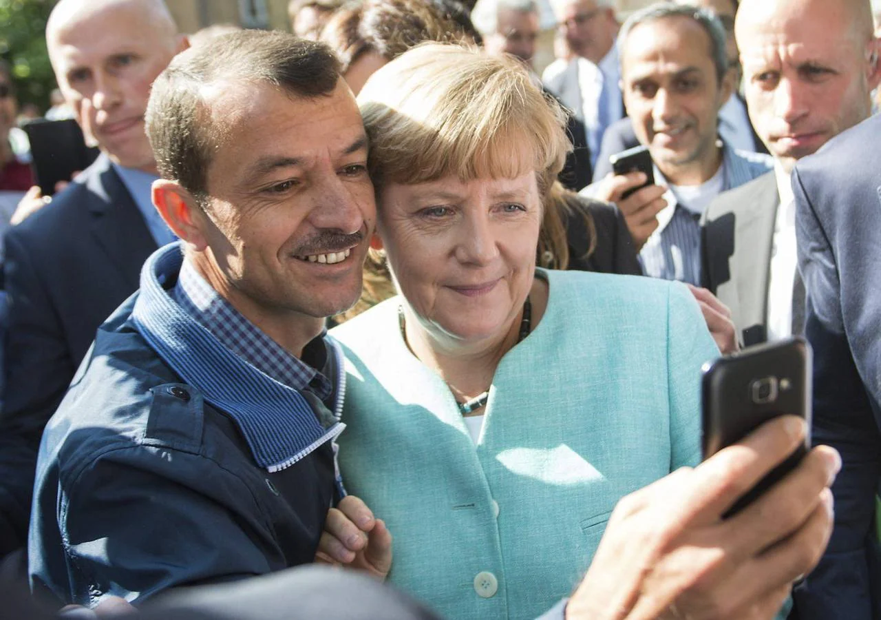 Un hombre se fotografía con Merkel durante una visita a la Oficina Federal de Migración y Refugiados en Berlín en 2015. 