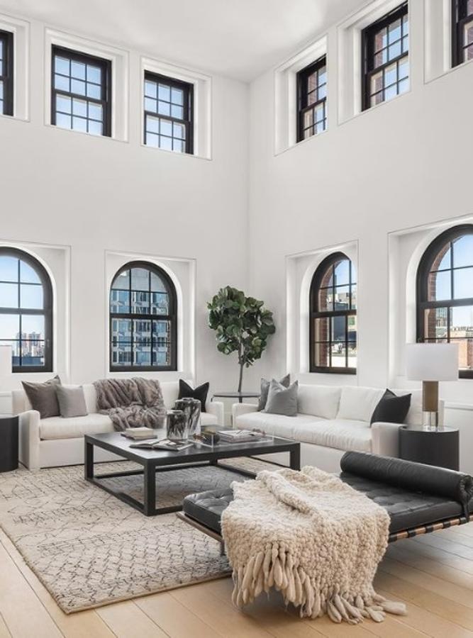 El ático que Lewis Hamilton ha vendido en Nueva York. El apartamento es un tríplex que cuenta con unos grandes ventanales que le confieren mucha luz y amplitud. La decoración se basa en el estilo nórdico, con grandes vigas de madera envejecida y mobiliario minimalista con detalles en tejidos confortables que hacen que se vea muy acogedor.
