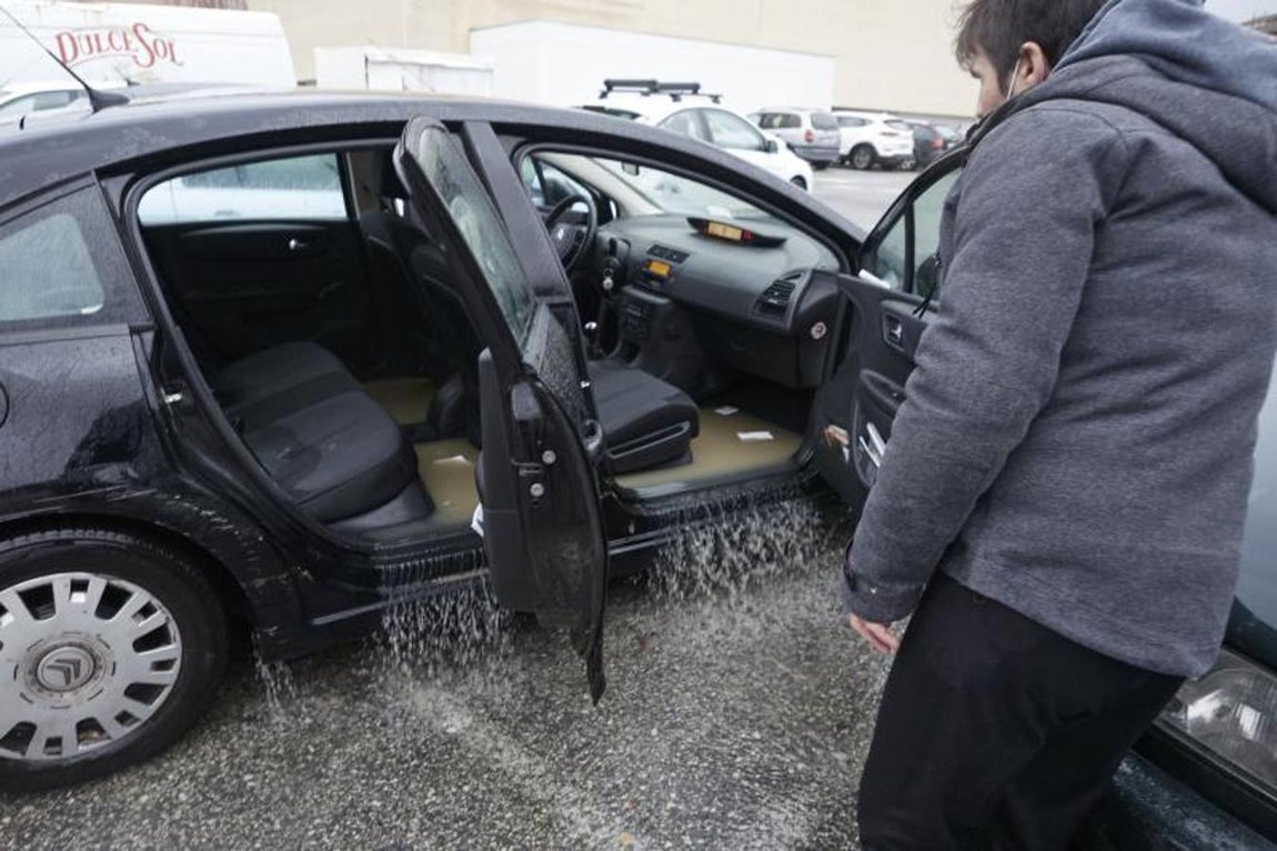 Un conductor sale de su vehículo que se encuentra en una zona inundada de Burlada, en Pamplona. 