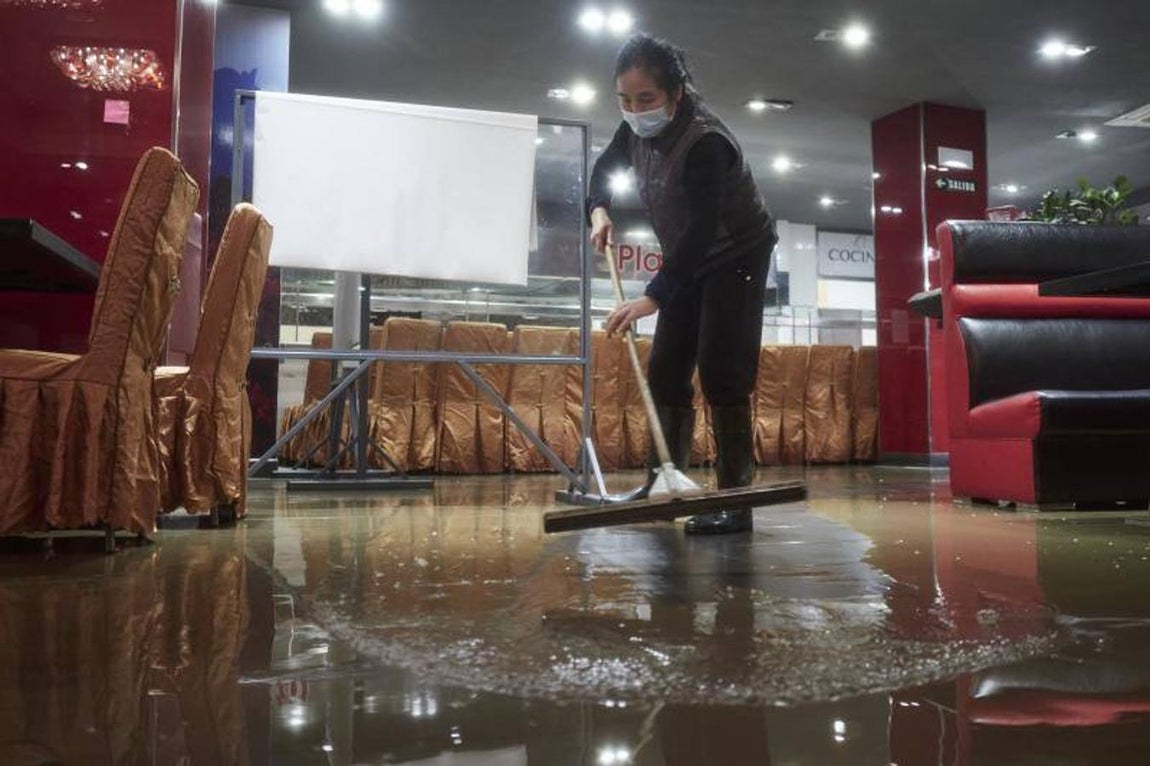 La dueña del restaurante WOK de la Rotxapea (Barrio de Pamplona) limpia y organiza el restaurante tras el desbordamiento del río Arga, a 10 de diciembre de 2021, en Pamplona, Navarra