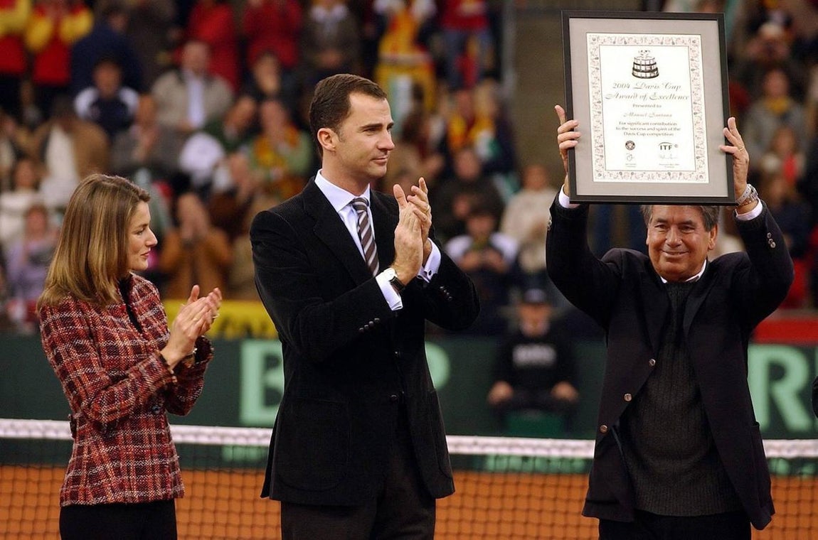 El rey Felipe VI (C) y la reina Letizia Ortiz (I), aplauden mientras la leyenda del tenis español Manolo Santana (D) sostiene el Premio a la Excelencia de la Federación Internacional de Tenis antes de disputarse la final de la Copa Davis en el Estadio Olímpico principal Tribunal en la ciudad de Sevilla, en el sur de España, el domingo 05 de diciembre de 2004. 