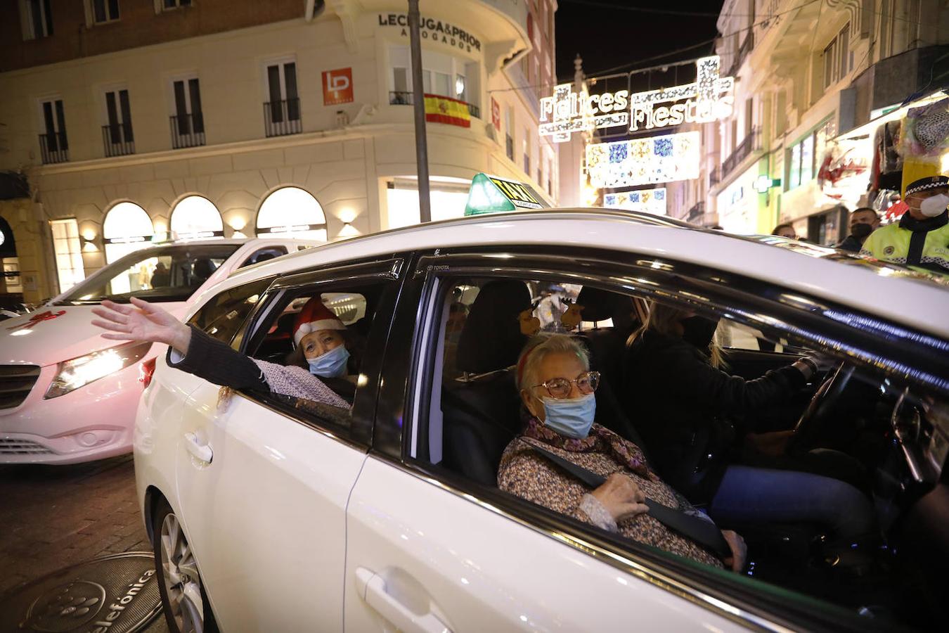 La ilusión de los mayores por la Navidad a través del reflejo del cristal de los taxis de Córdoba