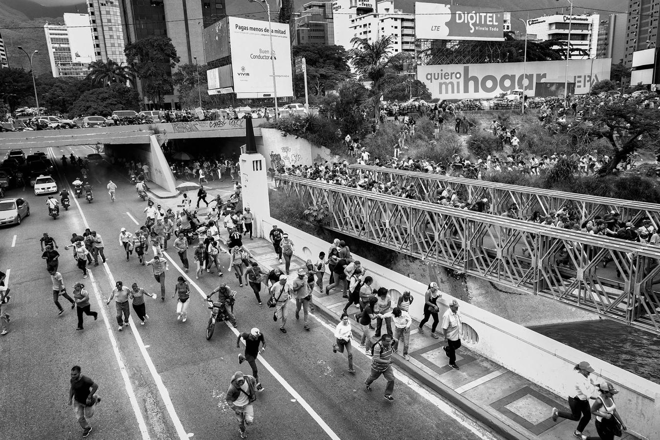 Un grupo de manifestantes contrarios al régimen de Maduro huye de la Policía chavista en junio de 2016, durante una marcha que acabó con violencia. 