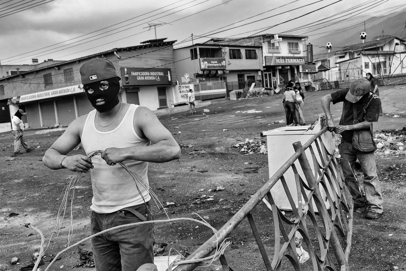 Varios estudiantes construyen barricadas contra el régimen en marzo de 2014 en San Cristóbal, la capital del estado de Táchira. La escasez de harina, leche y azúcar ha dificultado cada vez más su vida. 