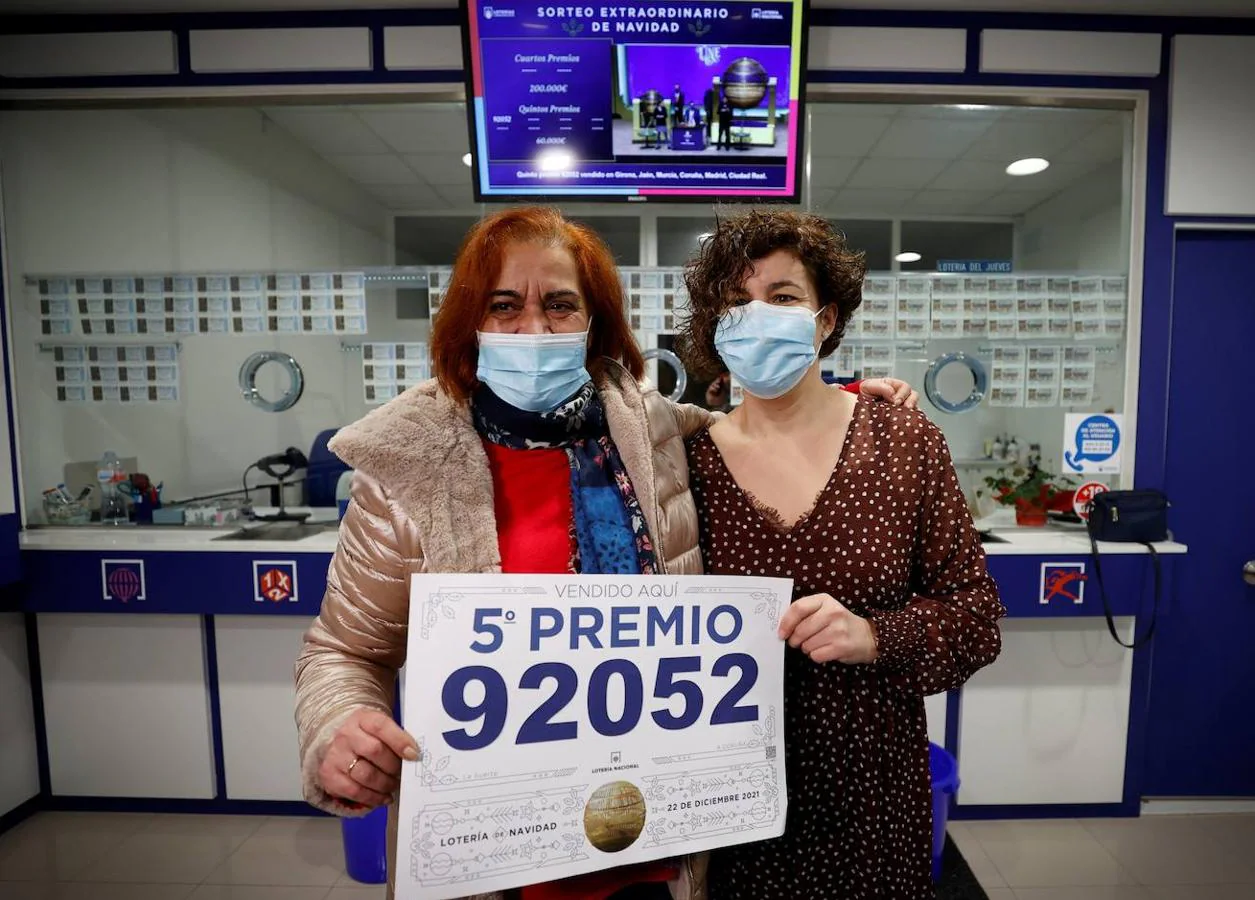 La lotera Celia Pedreira (i) y una empleada de la administración de la avenida de Oza de A Coruña, posan con el cartel del quinto premio. 