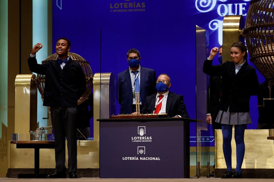 Momento en el que Alexander René Herrera y Aya Ben Hamdouch Chaaraqui cantan el segundo premio de la Lotería de Navidad. 