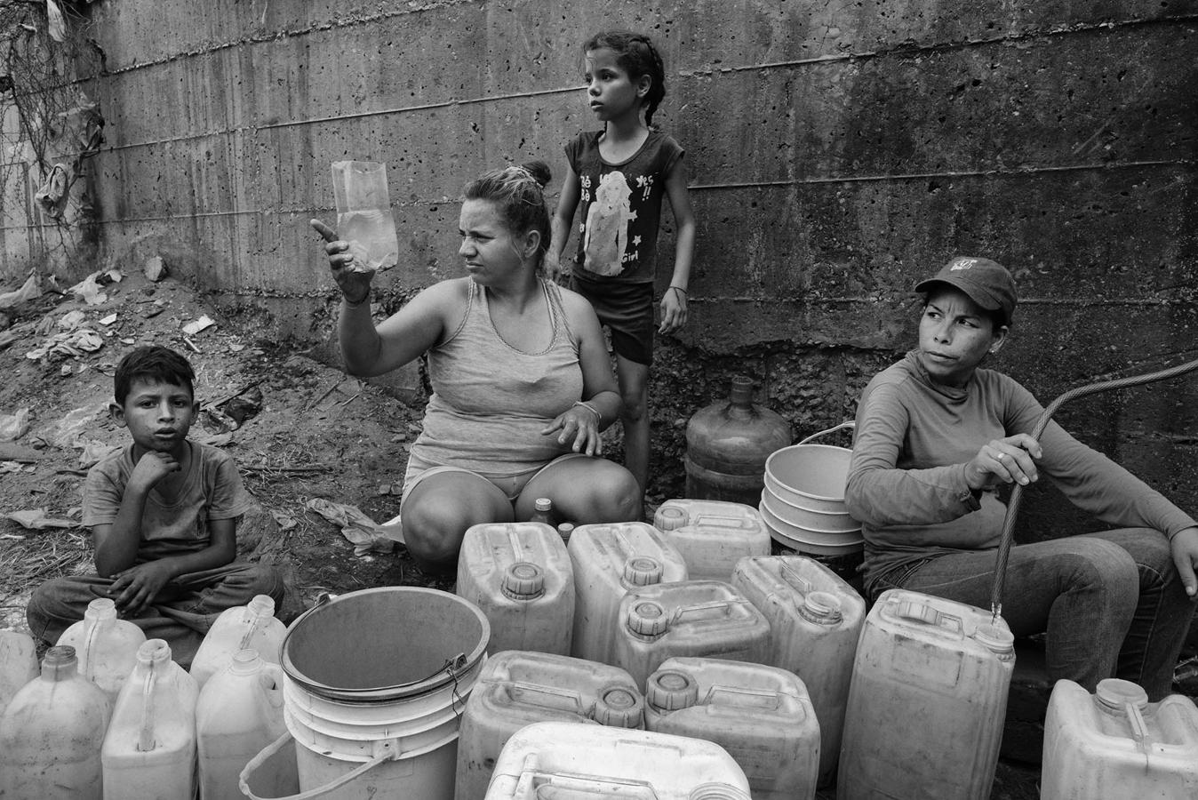 Varios civiles de la ciudad de Maracaibo recogen agua en abril de 2019 de tuberías, ríos y alcantarillas. 