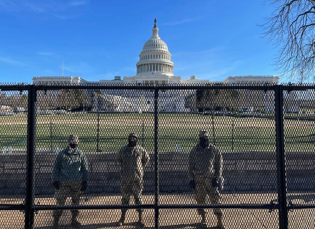 Los soldados de la Guardia Nacional de EE. UU. protegen los terrenos del Capitolio por detrás de una valla de seguridad en Washington. 