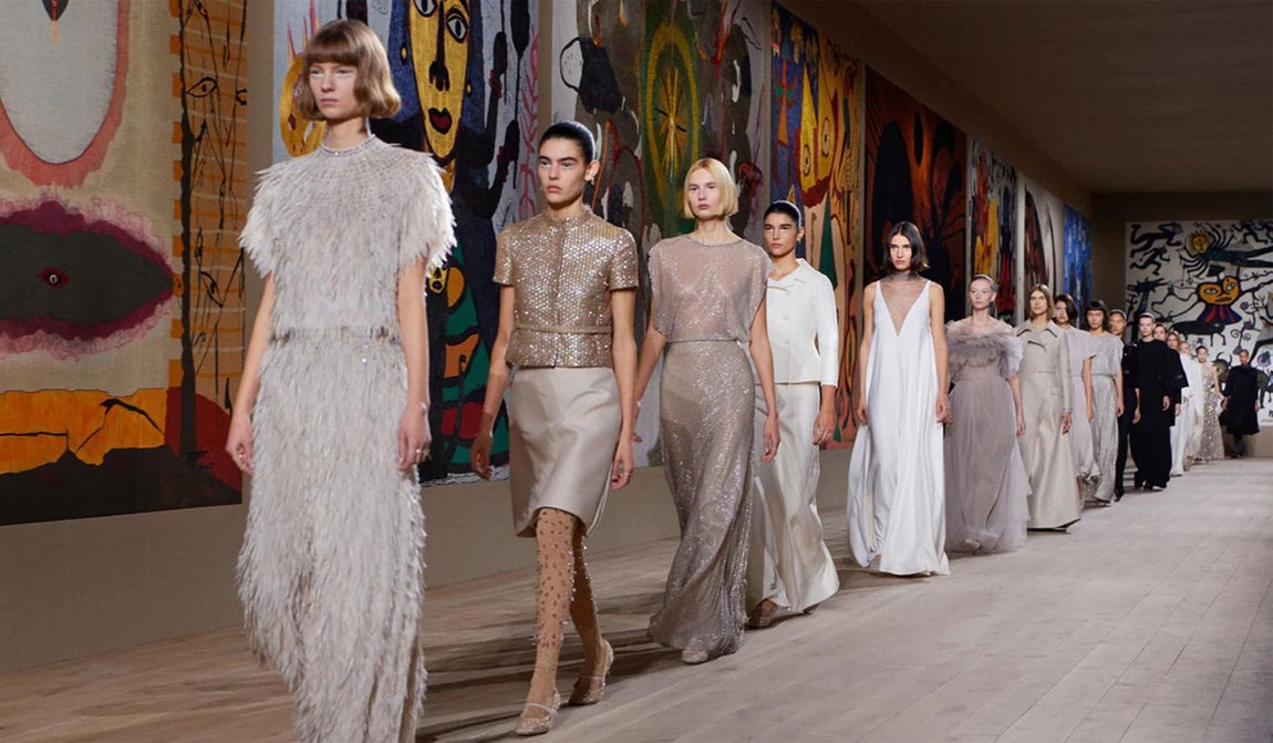 Dior Alta Costura primavera/ verano 2022. Plumas, medias joyas y bordados son algunos de los pilares fundamentales sobre los que se sostiene esta colección ideada por Maria Grazia Chiuri con la intención de honrar « las relaciones humanas con objetos hechos a mano, expresando el deseo de abolir las fronteras entre el arte y la artesanía de una vez por todas. El cuerpo es, por lo tanto, un vector para infundir vida en proyectos de vanguardia», explican desde la Maison. El bordado se convierte en un acto conceptual tridimensional que reinventa las técnicas y la excelencia elemental del taller. Las medias, también aprovechan el bordado para ofrecer una dimensión espectacular con joyas y elegantes combinaciones de tejidos. Los abrigos de cachemira abrazan la silueta y las elegantes capas en blanco resplandeciente ocultan conjuntos de chaqueta y pantalón. Las faldas plisadas ondean bajo abrigos estructurados, mientras que los tejidos jacquard de lamé plateado de los vestidos resaltan cada movimiento del cuerpo.