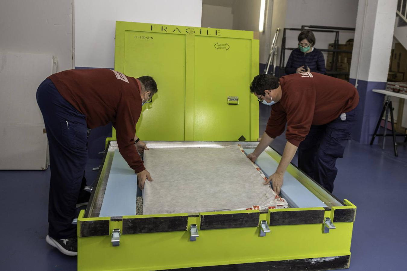 Dentro de la caja. Los empleados depositan el 'Mata Mua' en la caja antes de meterlo en el furgón. Se trata de una pieza de color chillón de 80 kilos y madera impermeabilizada que se fabricó expresamente para el traslado de 2020