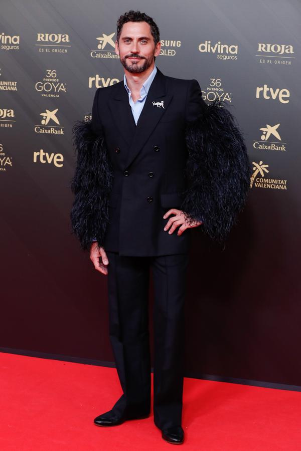 Paco León - Los looks masculinos de los Goya 2022. Fue uno de los más llamativos de la noche con un traje de Gucci con plumas de avestruz en las mangas y un broche de Cartier con la pantera de la firma.
