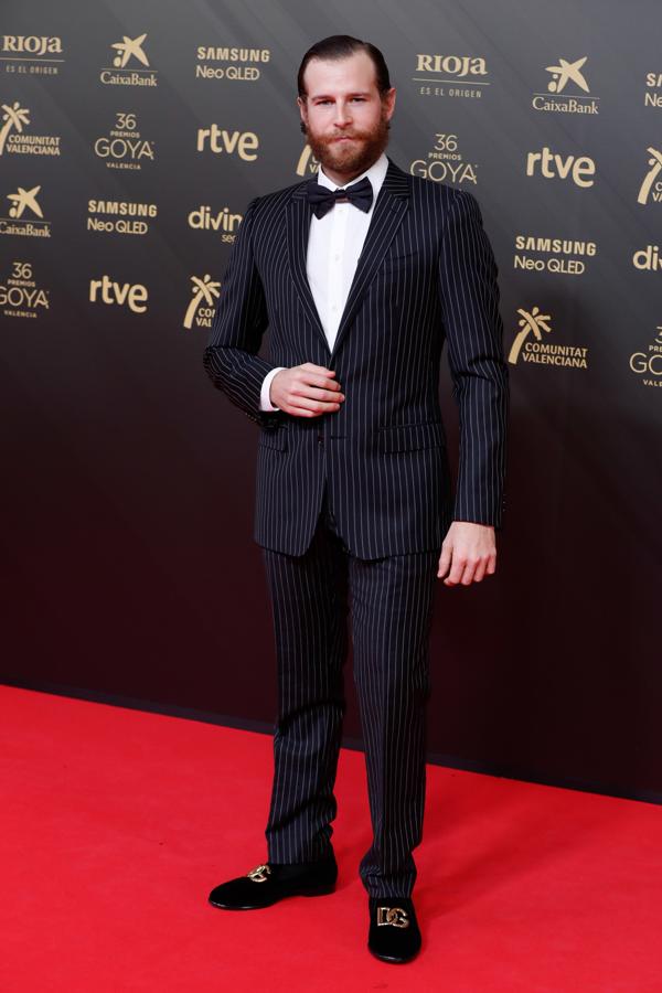 Álvaro Cervantes - Los looks masculinos de los Goya 2022. Muy elegante con un traje de raya diplomática de Dolce &amp; Gabbana que combinó con unas slippers de terciopelo de la misma firma.