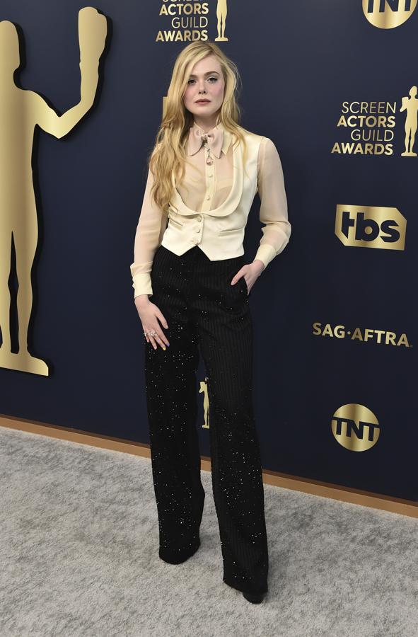 Elle Fanning - Los mejores looks de los SAG Awards 2022. Defendió con maestría este dos piezas de Gucci compuesto por un pantalón palazzo de raya diplomática con brillos, blusa semitransparente hueso y chaleco satinado.