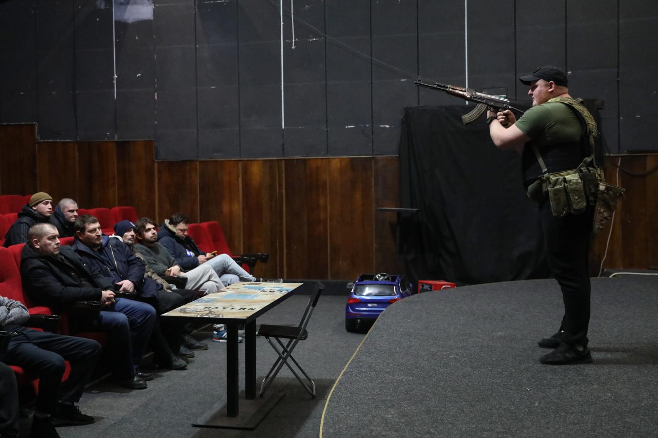 Un militar enseña a voluntarios ucranianos a utilizar un arma en un cine de Leópolis. 