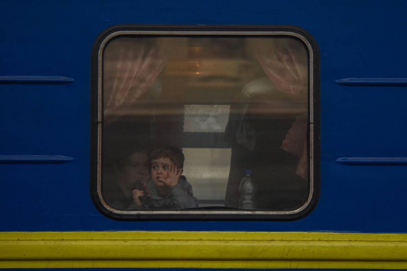 Un niño se despide desde la ventana de un tren que abandona la estación de Leópolis rumbo a Polonia. 