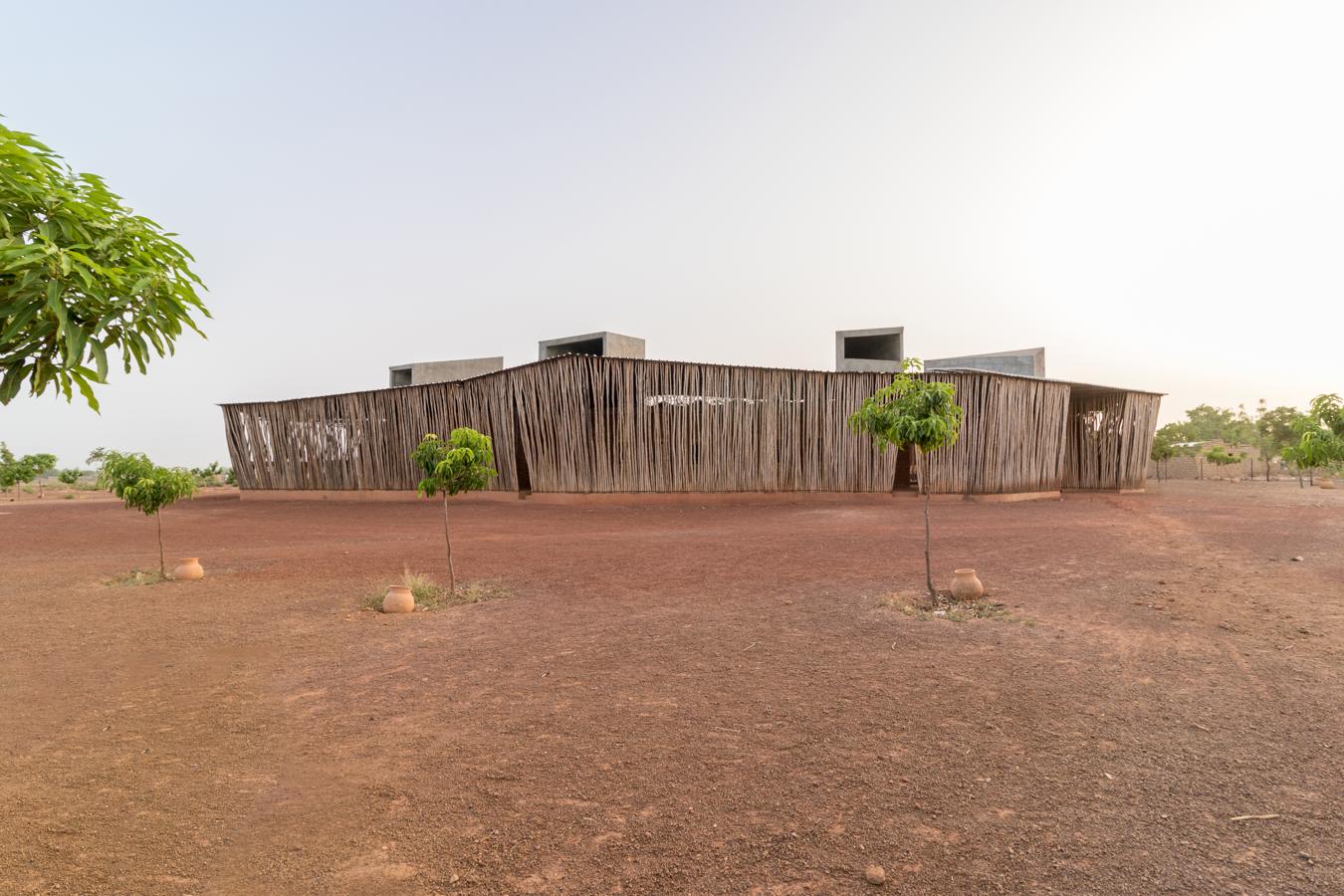 Escuela Secundaria Liceo Schorge. Situado en la tercera ciudad más poblada de Burkina Faso, Koudougou, el Liceo Schorge consta de nueve edificios modulares de laterita se disponen radialmente, creando un anillo central que sirve como espacio de uso comunitario. Una cubierta de metal corrugado protege de las inclemencias climáticas. En el interior, cubiertas abovedadas de yeso permiten regular la temperatura y la ventilación. Sus valores estéticos hacen de él un referente local.