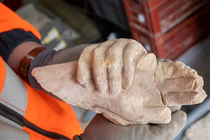 A apenas unos centímetros de la superficie, un arqueólogo limpiaba con delicadeza unas manos de piedra talladas y extendidas, como implorando.