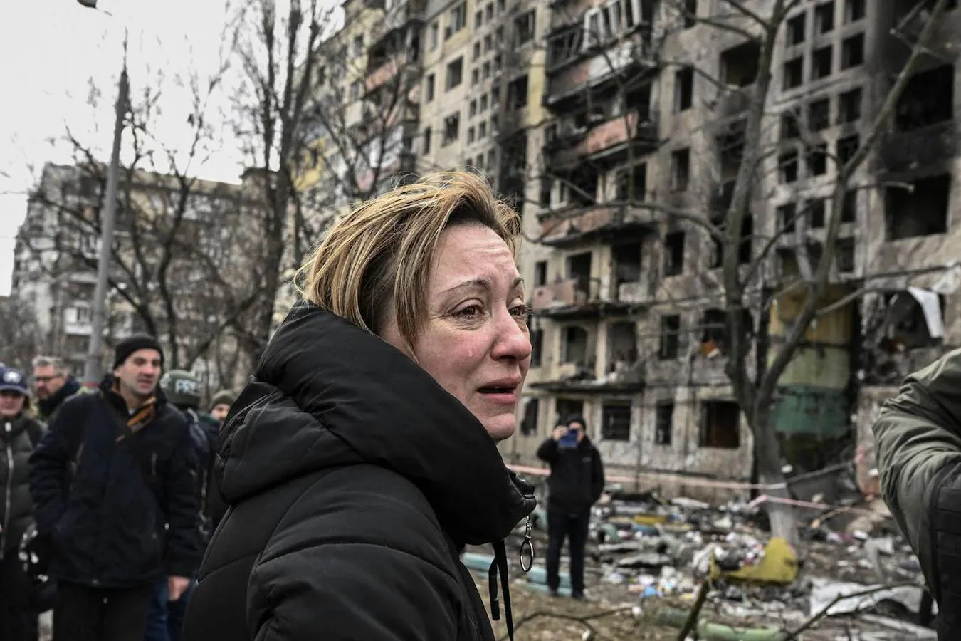 Desolados ante la devastación. Una mujer asiste impotente a la destrucción de un edificio en el distrito de Obolon de Kiev
