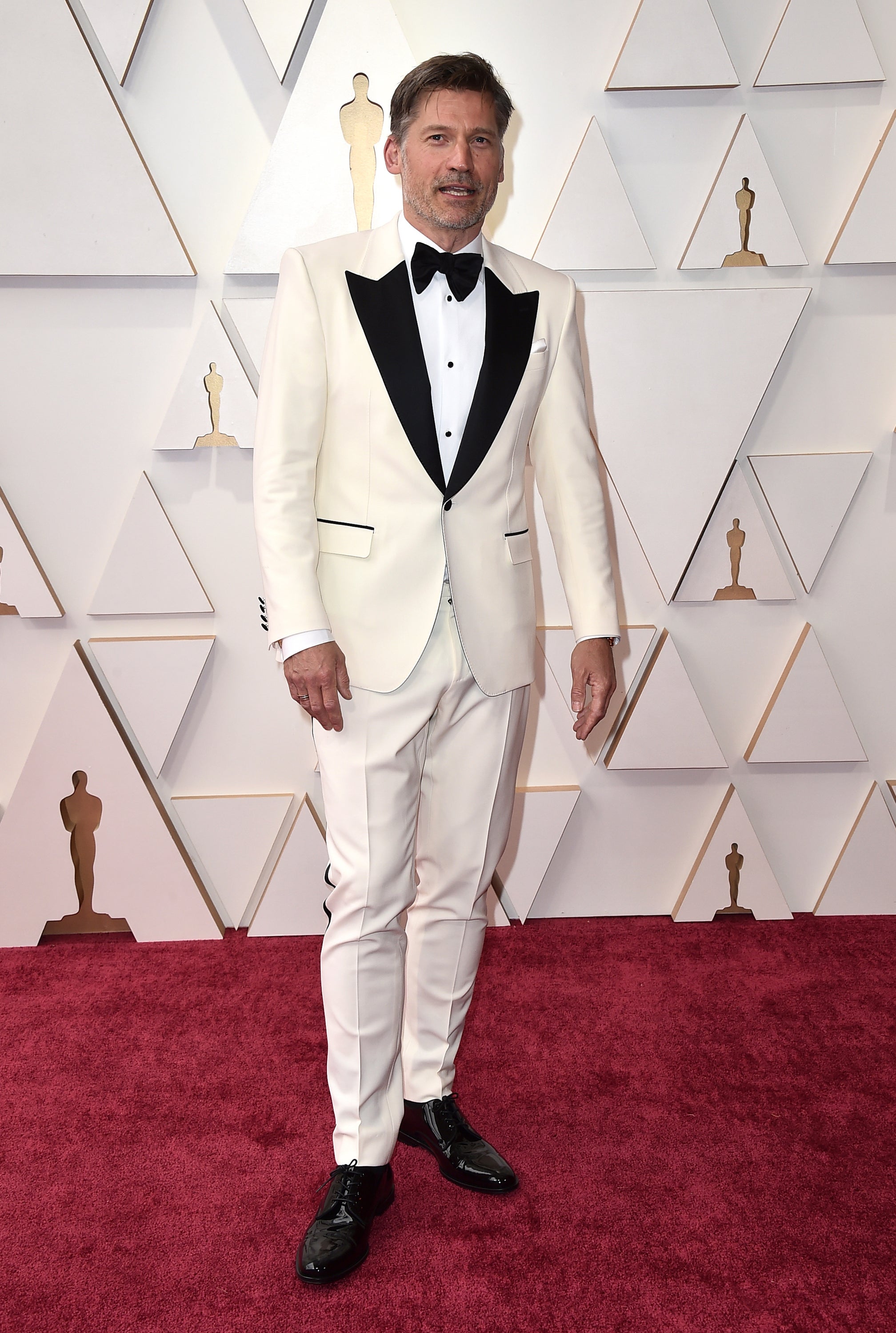 Nikolaj Coster-Waldau- Los mejor vestidos de los Oscar 2022. De blanco y con detalles negros, el esmoquin del actor está firmado por Dolce &amp; Gabbana.