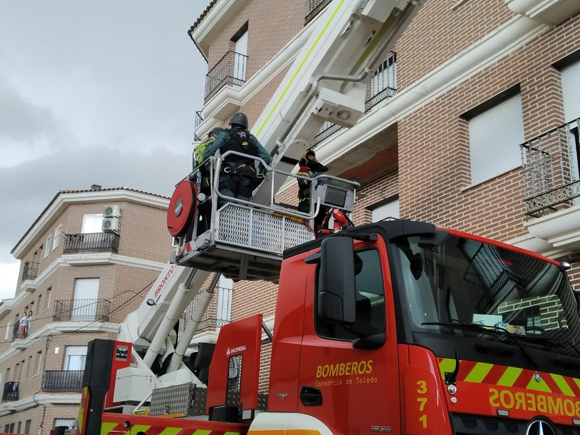 Dos guardias civiles suben en el brazo del camión de bomberos para accceder al inmueble abandonado justo enfrente del edificio donde estaba el hombre armado