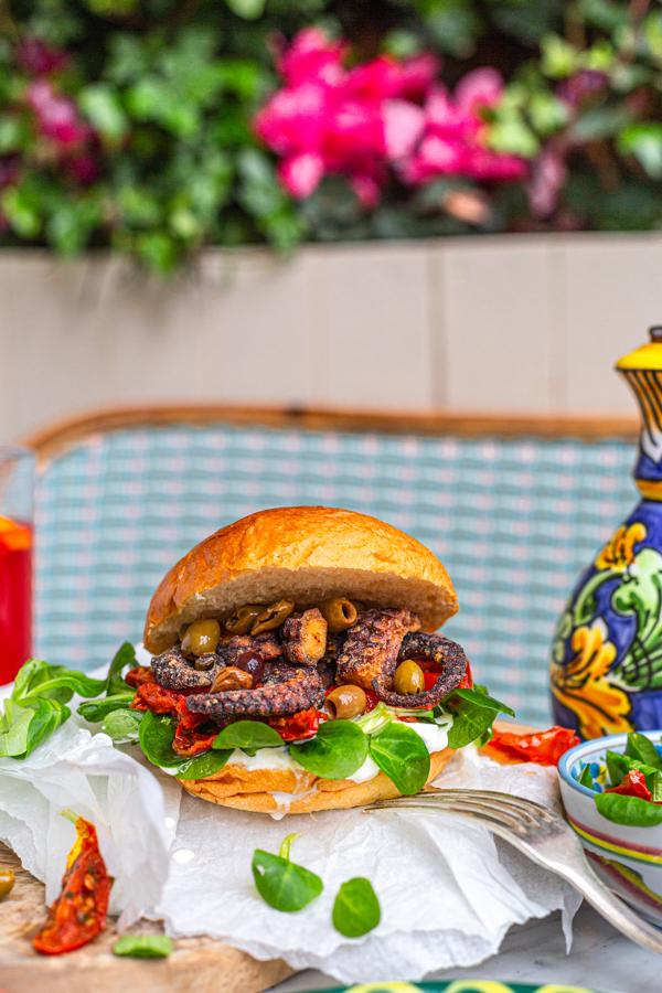 Una hamburguesa ‘delicatessen’ en Villa Capri. Para las madres más ‘foodies’. ¿Qué tal una invitación para degustar la nueva hamburguesa de Villa Capri, uno de los restaurantes más emblemáticos de la capital. Una delicia que rinde homenaje a la Costa Amalfitana, compuesta por pulpo fresco frito, stracciatella directa de Puglia, tomates semisecos, canónigos y una salsa de mayonesa con el propio jugo del pulpo, limón y eneldo y que se podrá degustar el 6, 7 y 8 de mayo (perfecto para los más rezagados que celebran esta festividad 'a posteriori). ¿Dónde? En la calle de Hortaleza 118. ¡Buon Appetito!
