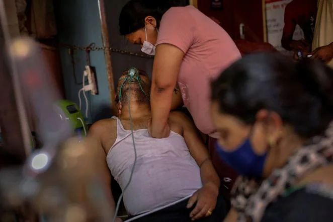 Manisha Bashu presiona el pecho de su padre, que tenía dificultades para respirar, después de quedar inconsciente mientras recibía oxígeno en un Gurudwara (un templo sij) en Ghaziabad, el 30 de abril de 2021