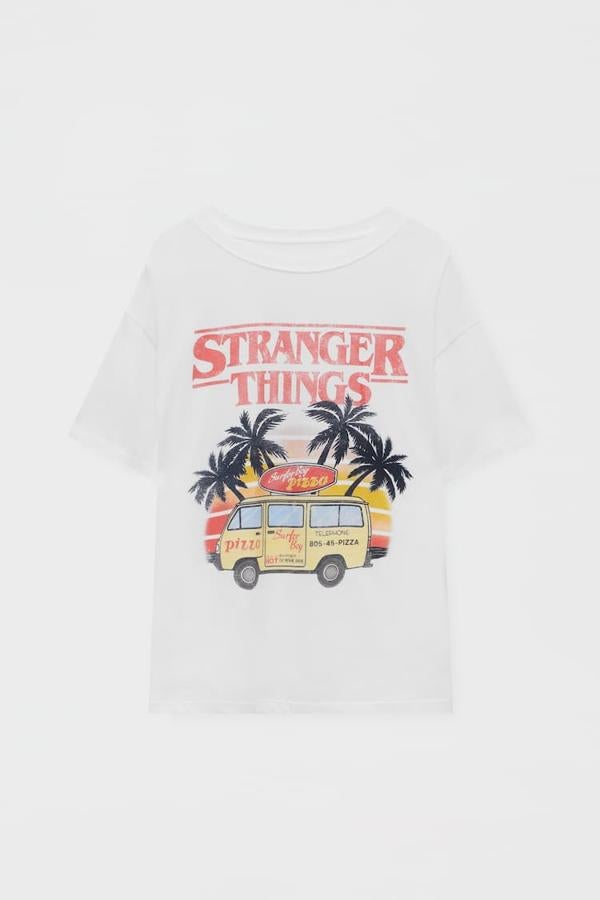 Pull&amp;Bear - Prendas inspiradas en Stranger Things. Camiseta blanca de algodón con cuello redondo y print central de estilo vintage, de Pull &amp; Bear. Precio: 15,99 €.