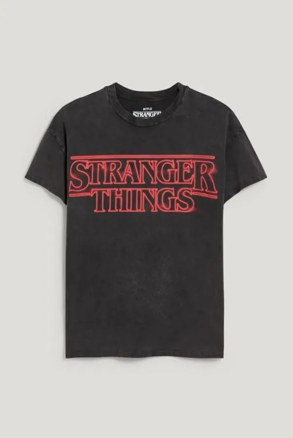 C&amp;A - Prendas inspiradas en Stranger Things. Camiseta básica gris pizarra con manga corta y el logo de la serie en rojo neón, de C&amp;A. Precio: 14,99 €.