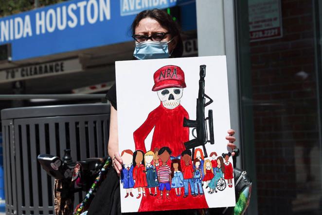 Una mujer sostiene una pancarta para denunciar las leyes sobre el acceso a las armas en EE.UU. a las puertas de la Convención Nacional del Rifle que se celebra estos días en Houston (Texas), poco después de la muerte de 19 personas tras el tiroteo en la escuela de Uvalde.