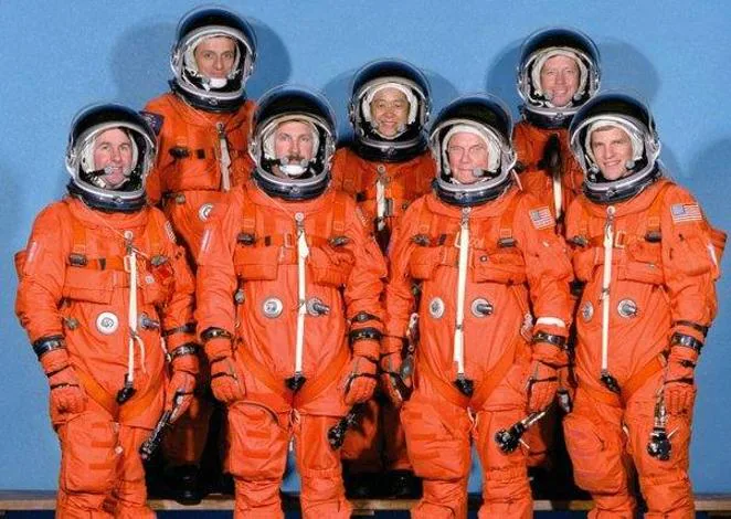 Vestimenta para momentos críticos. Pero, ¿y esos trajes naranjas en los que los astronautas estadounidenses se enfudan en las fotos? Se trata de los Advanced Crew Escape Suit o ACES, trajes espaciales utilizados en el transbordador. Fue diseñado para proteger a la tripulación en el caso de despresurización de la cabina para alturas de menos de 30 kilómetros. También sirve para proteger a los astronautas del aire frío y del agua en caso de un amerizaje. Dispone de un sistema de protección anti-G: unos sacos hinchables que presionan alrededor de las piernas y el abdomen inferior para que la sangre no se acumule en la parte inferior del cuerpo. El traje dispone de enfriamiento por circulación de líquido en su interior. En la imagen, arriba a la izquierda, podemos ver a un jovencísimo Pedro Duque.