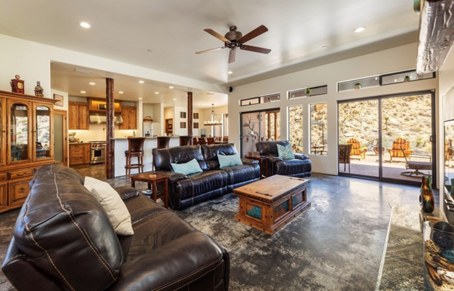 Así es el refugio de Amber Heard. La sala de estar, de techos altos y suelos de cemento pulido, cuenta con sillones de cuero envejecido, luces LED empotradas, una chimenea y una zona de bar con nevera para vinos.