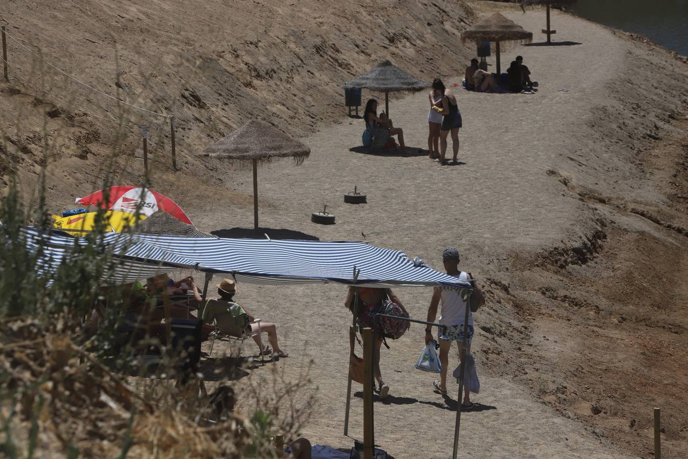 En imágenes, el primer baño veraniego en la playa del embalse de la Breña