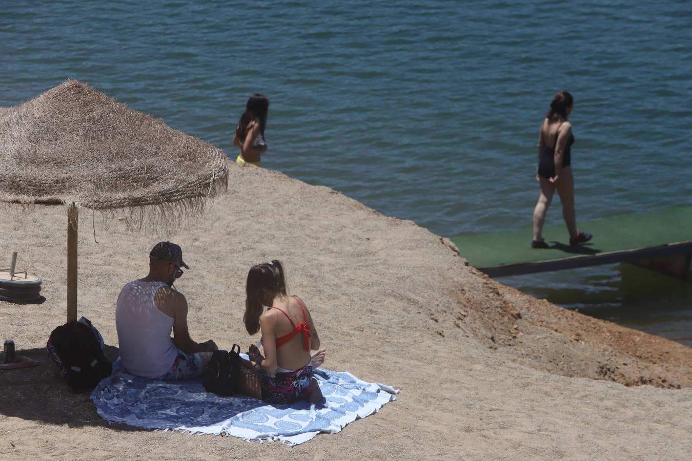 En imágenes, el primer baño veraniego en la playa del embalse de la Breña