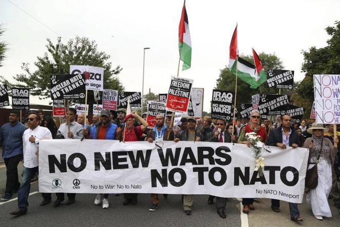 4 de septiembre de 2014. Manifestantes participan en una marcha hacia el hotel Celtic Manor, para mostrar su rechazo por la celebración de la cumbre bianual de la OTAN en Newport, Gales (Reino Unido). Los líderes de la Alianza Atlántica se reunieron para debatir sobre la fase final de su intervención en Afganistán y la confrontación con Rusia por la crisis ucraniana, además de la preocupación por la violencia del Estado Islámico en Irak.. 