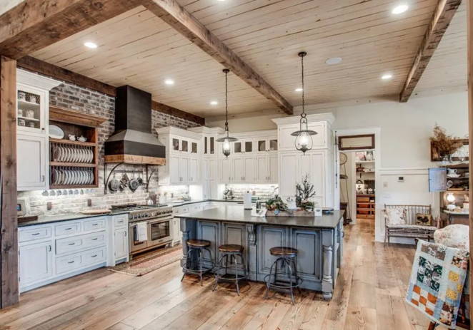 Así es el rancho que ha vendido Miley Cyrus. La cocina, que está abierta a una sala de estar con chimenea, cuenta con gabinetes en color blanco, electrodomésticos de Wolf y Sub-Zero y una gran isla central con espacio extra de almacenaje y barra de desayuno.