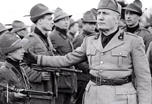 Benito Mussolini en un desfile de camisas negras, con veteranos y niños entre sus filas