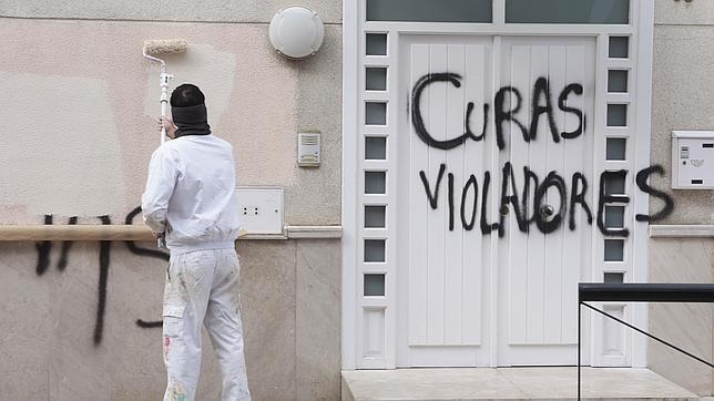 Un operario retira las pintadas que aparecieron en la iglesia al destaparse el caso