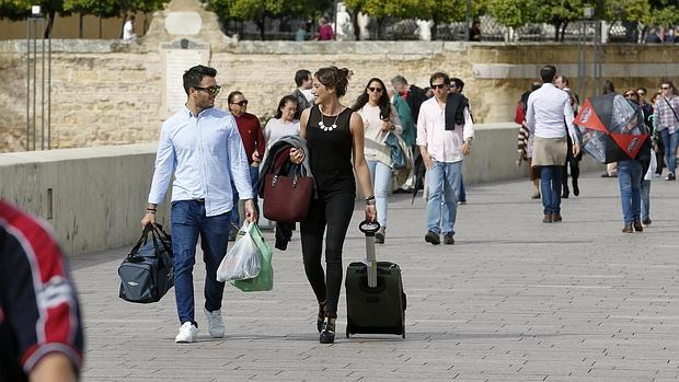 Una turista se pasea en camiseta por el Puente Romano en pleno otoño