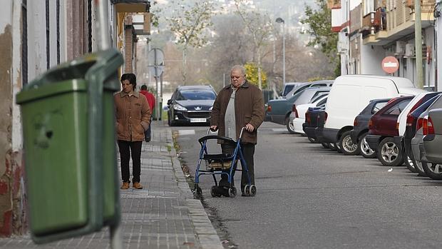 Una persona mayor camina por las aceras en mal estado del barrio