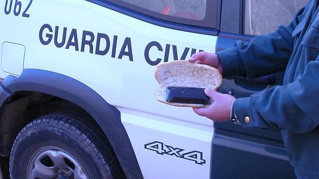 Un agente muestra un bocadillo que contenía en su interior una tableta de hachís