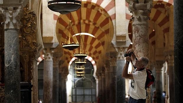 Un turista fotografía los arcos en el interior de la Mezquita-Catedral