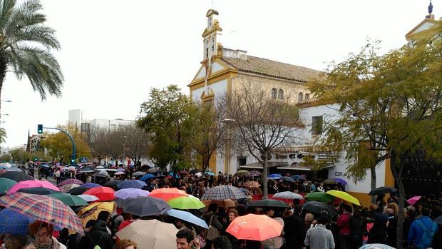 Fieles ante las puertas de la parroquia del Zumbacón para ver a la Merced, que ha suspendido su salida