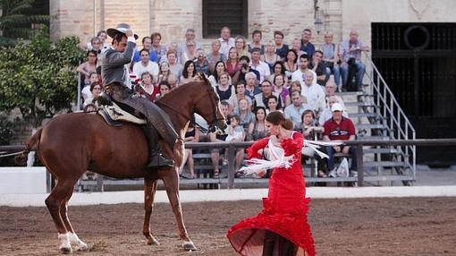 Una flamenca danza junto a un caballo