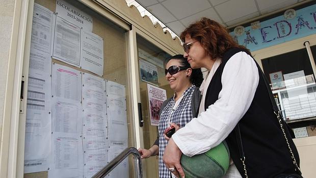 Familiares consultan en un colegio las listas de escolarización en el curso 2013/2014