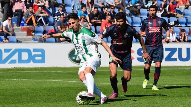 Fidel controla el balón ante la mirada de dos jugadores del Huesca