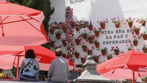 Una pareja admira la Cruz de Mayo ubicada en la Cuesta del Bailío