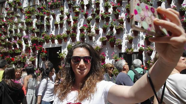 Una joven se hace un selfie en uno de los Patios de Córdoba