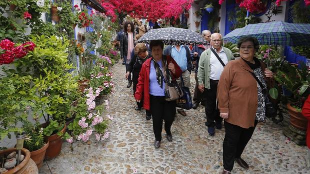 Visitantes en el Patio de Marroquíes, 6 ataviados con paraguas