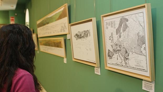 Una joven admira los dibujos expuestos en la exposición sobre Carandell